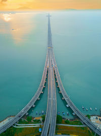 Aerial view of bridge over sea during sunset