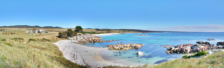 Panoramic view of beach against clear blue sky