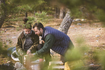 Couple holding firewood at campsite