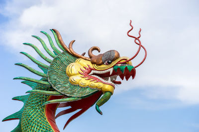 Low angle view of dragon statue against sky