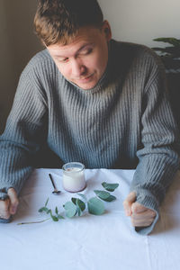 Midsection of man sitting at table