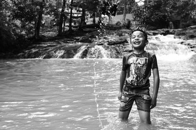 Portrait of happy boy standing in water