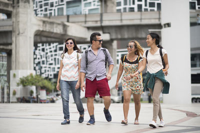 Friends talking while walking in city