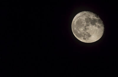 Low angle view of full moon against clear sky at night