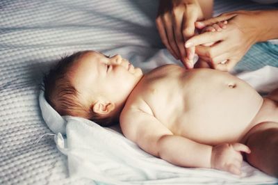 Woman holding baby boy hand at home