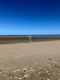 Scenic view of beach against clear blue sky