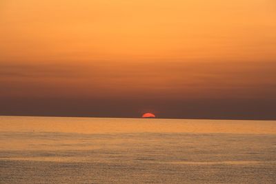 Scenic view of sea against orange sky