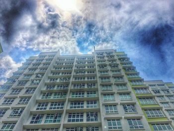 Low angle view of buildings against cloudy sky