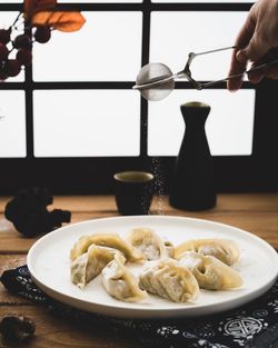 Cropped hand of person preparing food on table