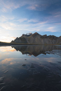 Scenic view of lake by mountains against sky