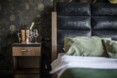 Wineglasses with bucket on side table in bedroom