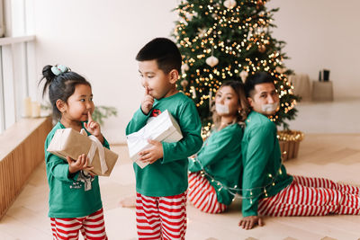 The children tied their parents with rope. an asian family is having fun playing a christmas holiday