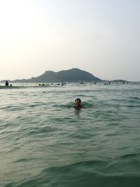 Woman swimming in sea against sky