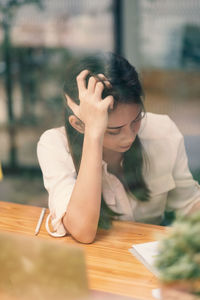 Portrait of young woman sitting on table