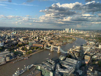 High angle view of city buildings against cloudy sky