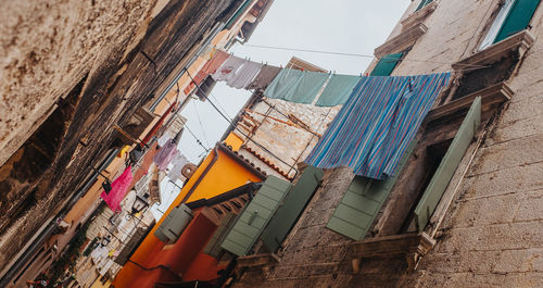 Low angle view of clothes hanging on building against sky