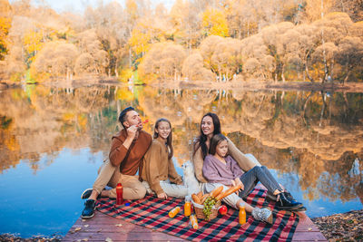 Family sitting by lake