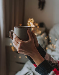 Close-up of hand holding coffee cup