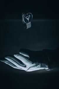 Close-up of hand over black background