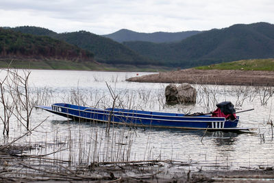 A fishing boat is standing still at the dam with a beautiful view