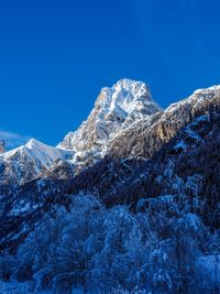 Snowcapped mountains against clear blue sky