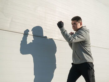 Low angle view of man standing against wall