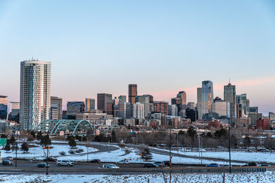 Buildings in city against clear sky during winter