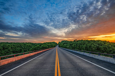 Empty road against sky during sunset