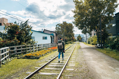 Full length of man walking on railroad track against sky