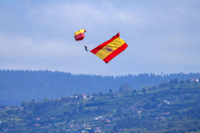 Low angle view of person paragliding against sky