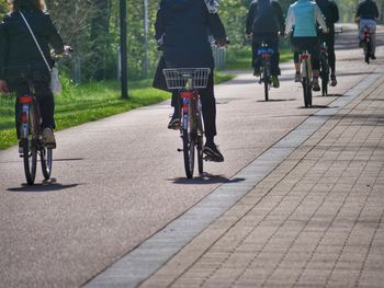 Low section of women riding bicycle on footpath