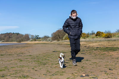 Portrait of woman with dog against sky