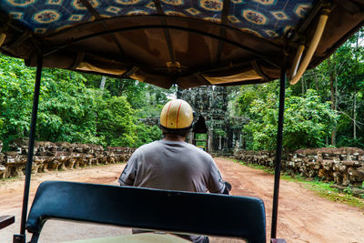 Rear view of man driving scooter