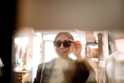 Young woman trying sunglasses at fashion store