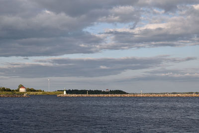 Scenic view of sea by buildings against sky