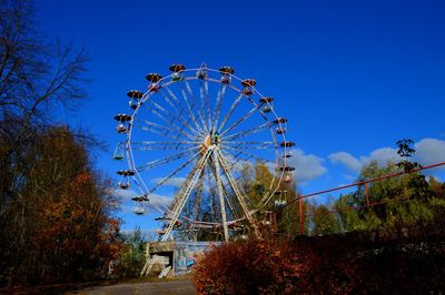 Low angle view of ferris wheel against clear blue sky