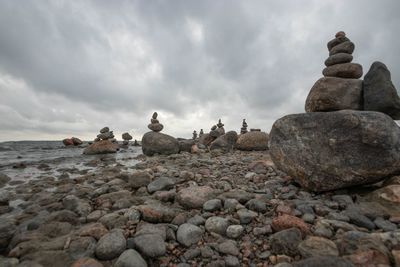 Stack of stones on shore against sky
