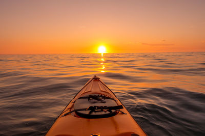 Cropped image of kayak in sea against sky during sunset