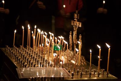 Religious cross surrounded with burning candles in church