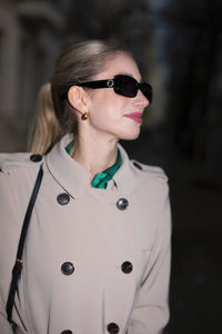 Portrait of young woman wearing sunglasses standing outdoors