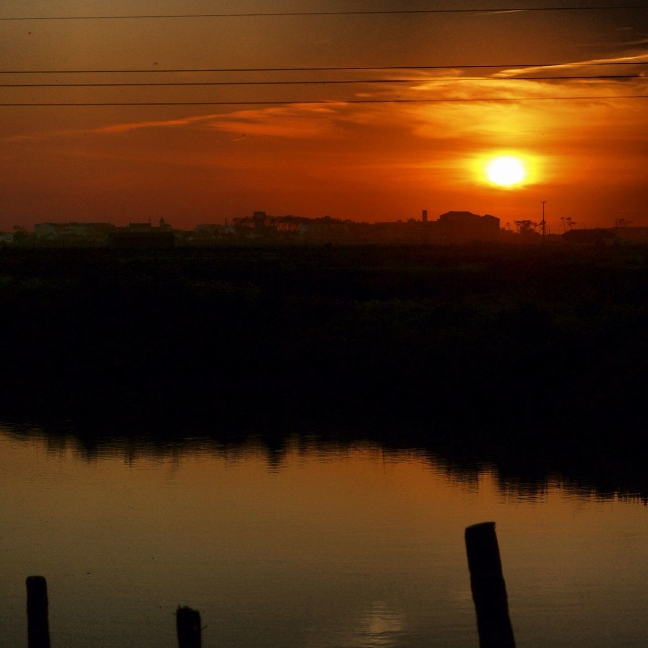 sunset, water, tranquil scene, scenics, tranquility, reflection, beauty in nature, lake, sun, orange color, silhouette, nature, sky, idyllic, river, waterfront, landscape, sunlight, tree, no people