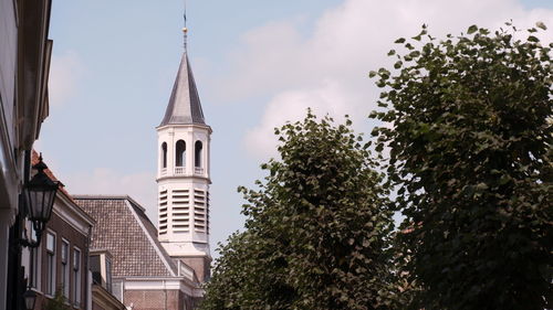 Low angle view of trees and buildings against sky