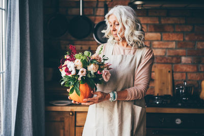 Portrait of woman standing by christmas tree