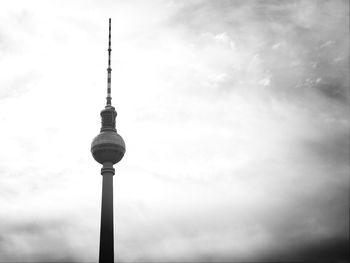 Low angle view of fernsehturm against cloudy sky