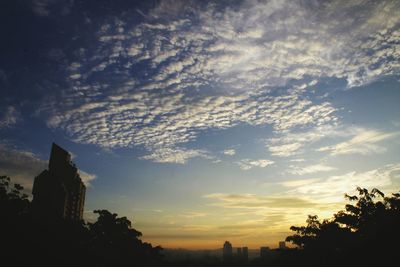 Silhouette of building against cloudy sky