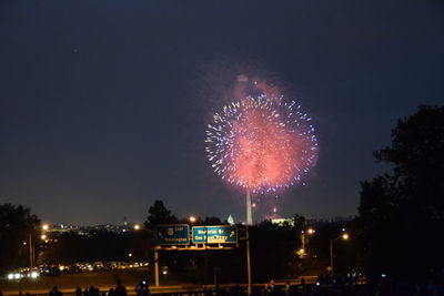 Low angle view of fireworks against sky at night