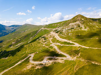 Winding road from high mountain pass, in summer time. aerial view by drone. romania