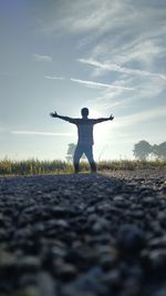 Full length of man standing on field against sky