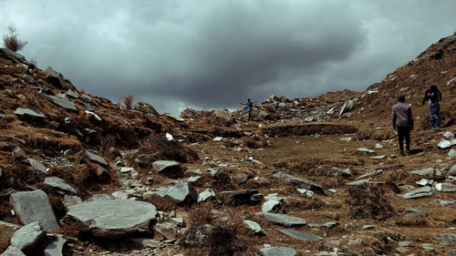 People on rocks against sky