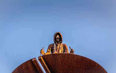 Low angle view of statue against blue sky